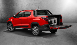 Parte traseira da Fiat Strada Volcano vermelha, com caçamba elevada, lanternas em LED e acabamento robusto, em ambiente urbano.