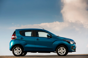 Fiat Mobi azul estacionado com céu aberto e nuvens ao fundo, destacando o visual compacto e urbano do modelo.