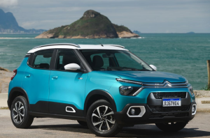 Citroën C3 azul estacionado com o mar ao fundo e céu aberto iluminando a cena.