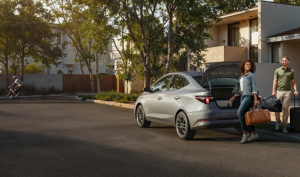 Duas pessoas se aproximando de um Hyundai HB20S estacionado, prontas para entrar no veículo