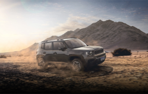 Jeep Renegade em movimento levantando poeira, rodeado por árvores em um cenário natural e bonito.