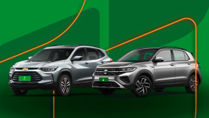 Tracker e T-Cross lado a lado em primeiro plano, fundo chapado verde e alaranjado da Localiza