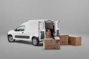 Fiat Fiorino com a traseira aberta, caixas no chão e destaque para o amplo espaço de carga do furgão.