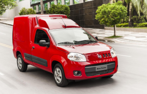 Fiat Fiorino vermelha em movimento, destacando o design robusto e a versatilidade do furgão compacto.