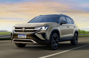 carro Volkswagen Taos cinza em movimento na estrada, destaque para o design robusto e moderno do SUV.