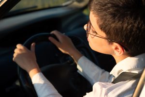 Beautiful young businesswoman driving car on a sunny summer day.