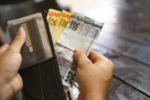 human-hand-taking-real-bills-out-of-wallet