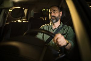 mid-aged-man-driving-his-car-at-night