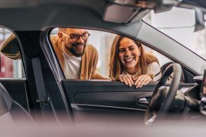 a-couple-looking-inside-a-new-car-at-the-dealership