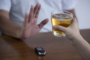 Don't drink drive and Man refusing alcohol beer showing car key as gesture of don't drink and drive