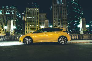 Downtown Parked Car at Night. Downtown Chicago Parking Space. Five Doors Yellow Car with Lights On.