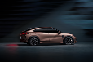 BYD na cor rose posicionado em estúdio com fundo preto texturizado. O carro está destacado pelas luzes indiretas