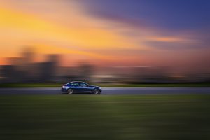 sideviewofafast-movingcarwithablurredsunset