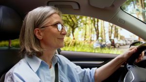 mulher idosa dirige o seu carro