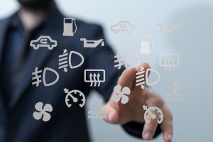 Pessoa com o dedo na tela, que indica vários símbolos do painel do carro