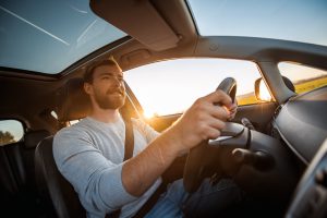 young-man-driving-car-on-a-sunny-day