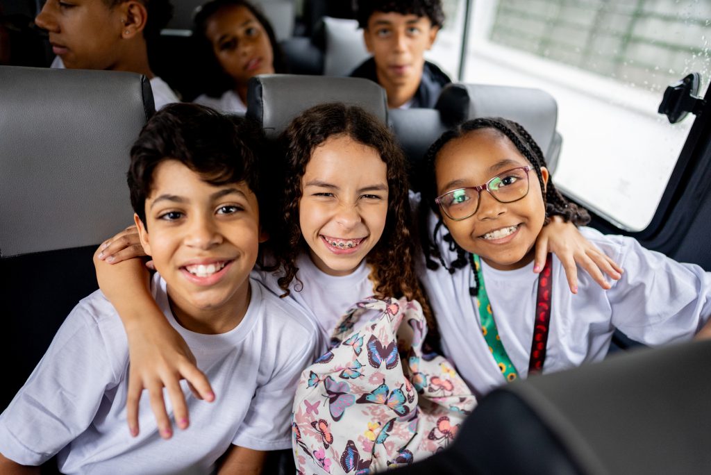Portrait of elementary students inside of school van
