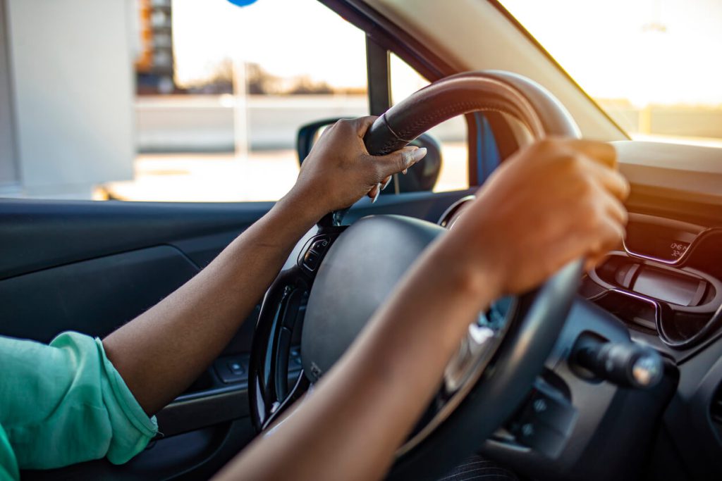 Mãos femininas segurando o volante