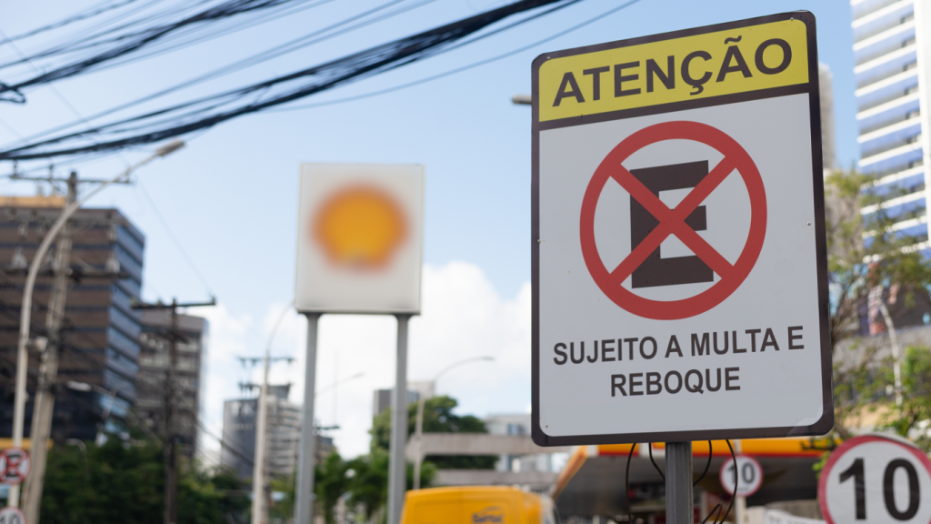 Placa de proibido parar e estacionar reforça informação de multa e reboque.