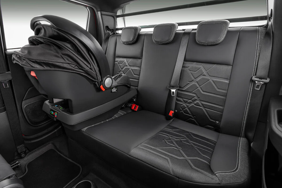 Interior da Fiat Strada com foco nos bancos e espaço interno, destacando o estofado em tecido e o bom aproveitamento da cabine.