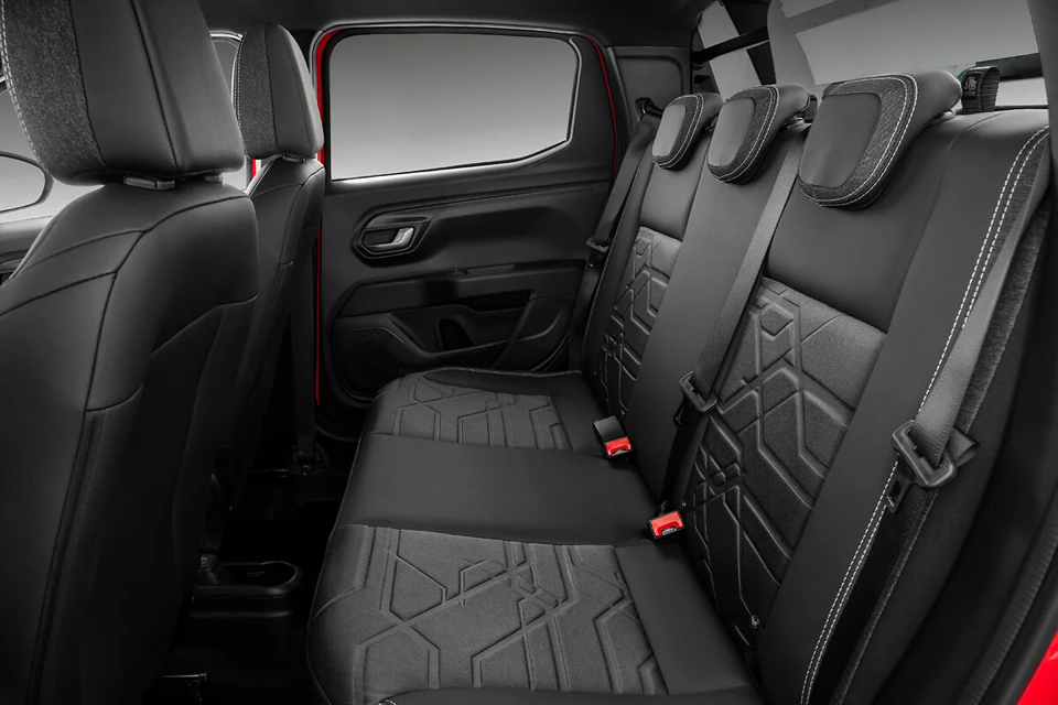 Interior da Fiat Strada com foco nos bancos traseiros, revestimento em tecido, encostos confortáveis e espaço para até cinco ocupantes.