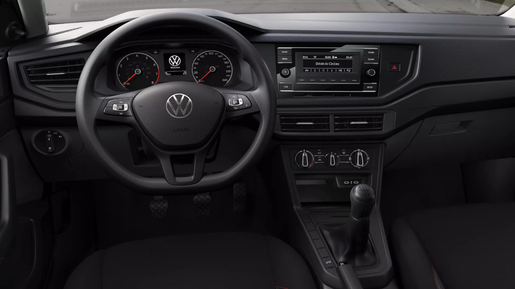 Interior do Volkswagen Polo Track, com painel simples, volante multifuncional e central multimídia integrada.