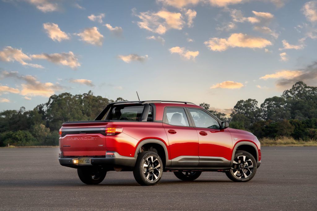 Chevrolet Montana vermelha estacionada, vista traseira, destacando a caçamba ampla e o design moderno da picape.