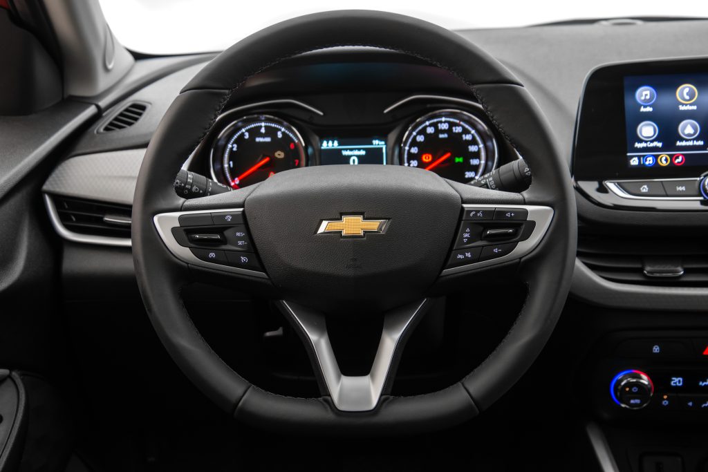 Painel do Chevrolet Onix com volante multifuncional e central multimídia em destaque.