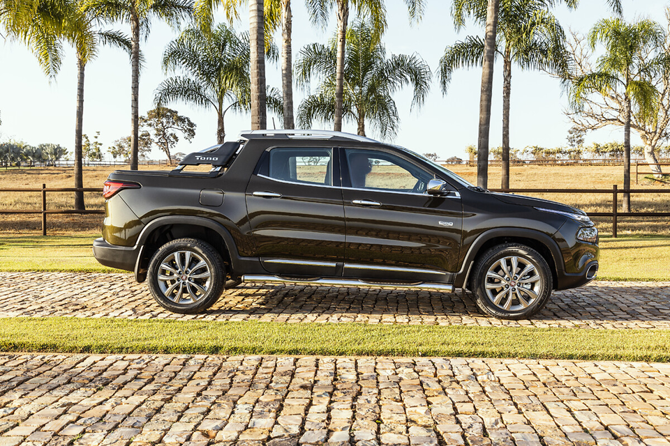 Fiat Toro Ranch vista de lado, exibindo a carroceria com acabamento sofisticado, rodas exclusivas e detalhes cromados.