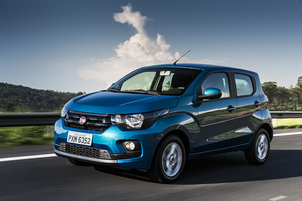 Fiat Mobi azul em movimento em uma estrada, com destaque para o design compacto e urbano do modelo.