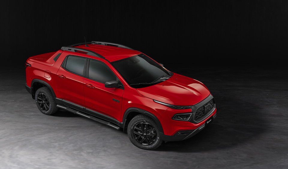 Fiat Toro Ultra Turbo vermelha vista de frente em movimento, destacando o visual imponente e os detalhes escurecidos da versão.