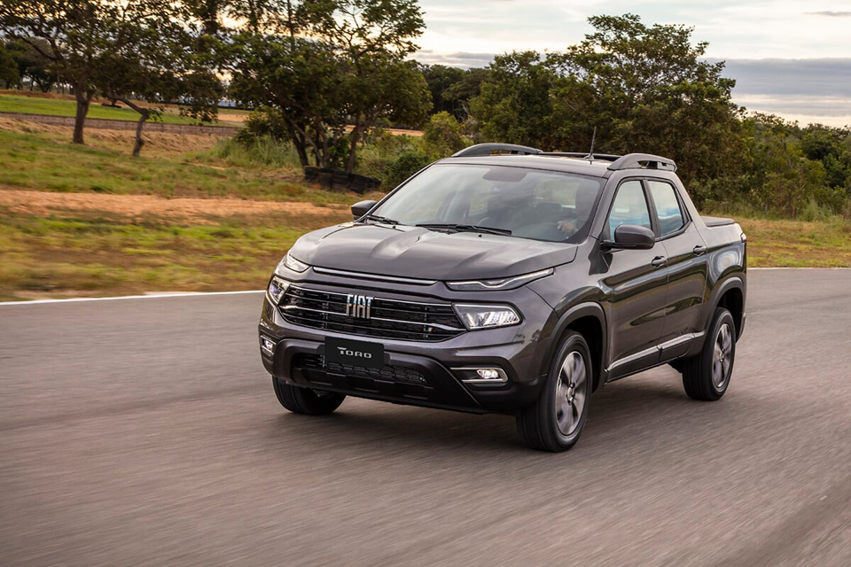 Fiat Toro Freedom preta em movimento na estrada, com caçamba espaçosa e design equilibrado entre robustez e conforto.







