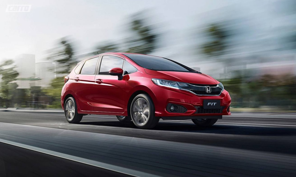 Honda Fit vermelho em movimento na estrada, destacando design compacto e versatilidade