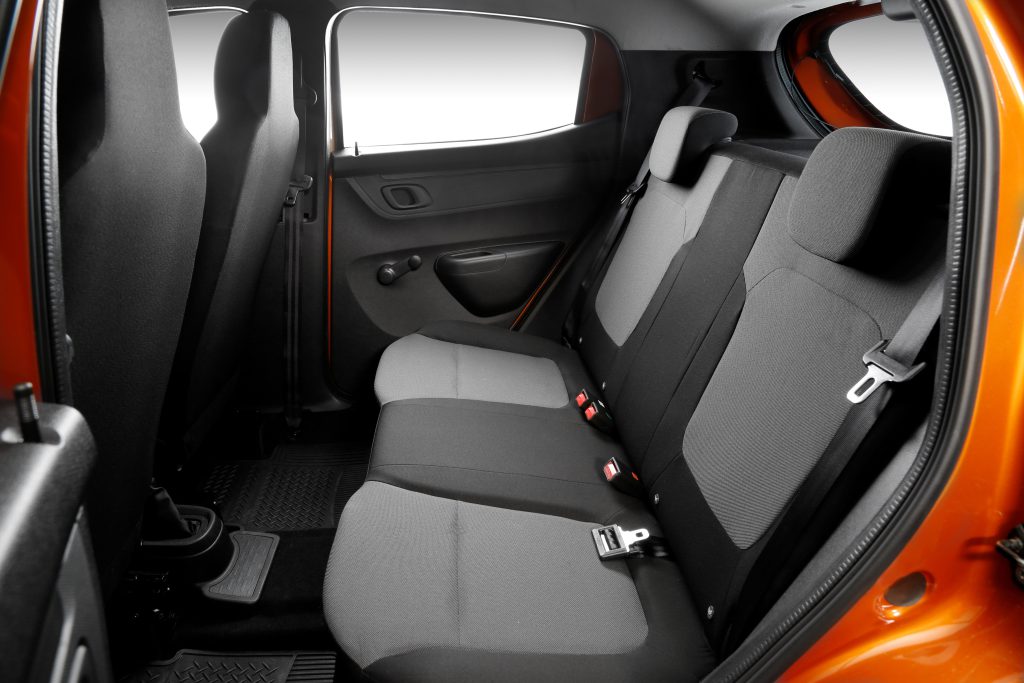 Espaço interno do Renault Kwid visto pelos bancos traseiros, com assentos compactos e encostos rebatíveis