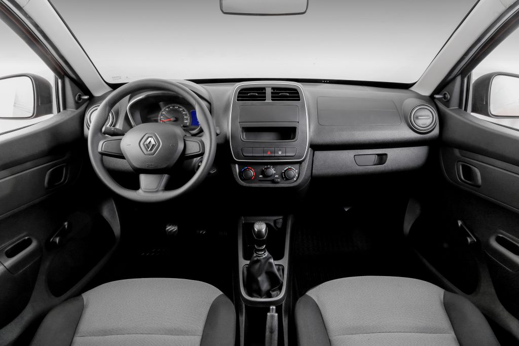 Interior do Renault Kwid com painel central, volante multifuncional e acabamento simples e funcional