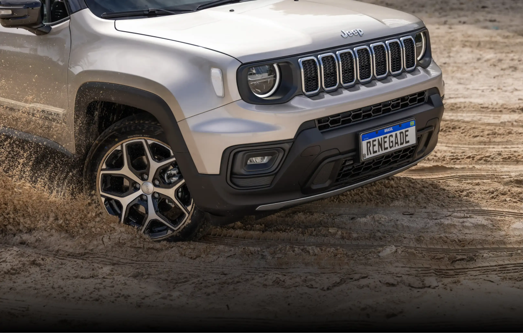 Jeep Renegade cinza em alta velocidade na estrada, destacando robustez e estilo aventureiro do SUV.