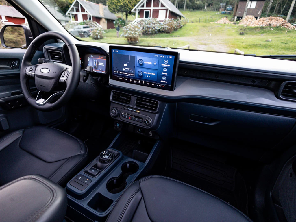 Interior da Ford Maverick com foco na central multimídia, destacando a tela sensível ao toque e os comandos digitais no painel.
