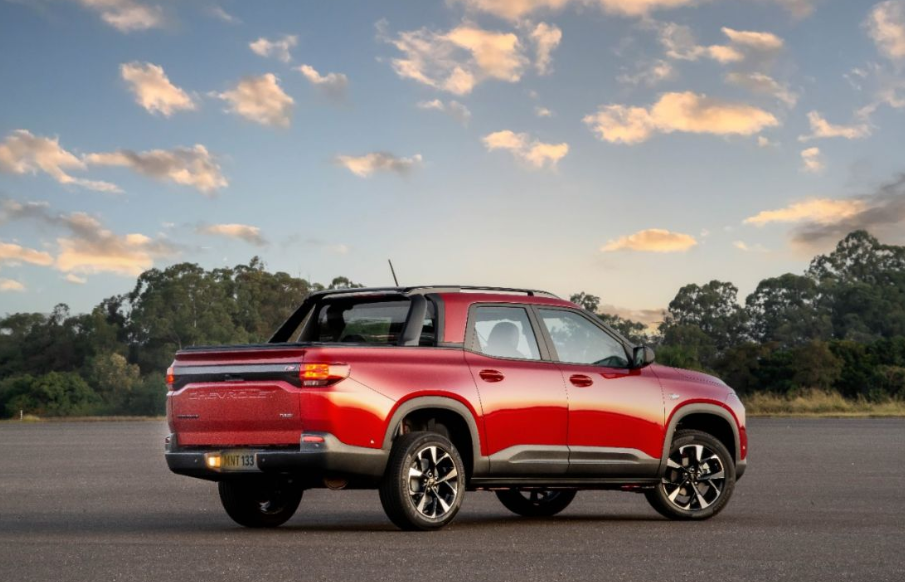Chevrolet Montana vermelha em ambiente ao ar livre, com foco na parte traseira e destaque para a caçamba da picape.