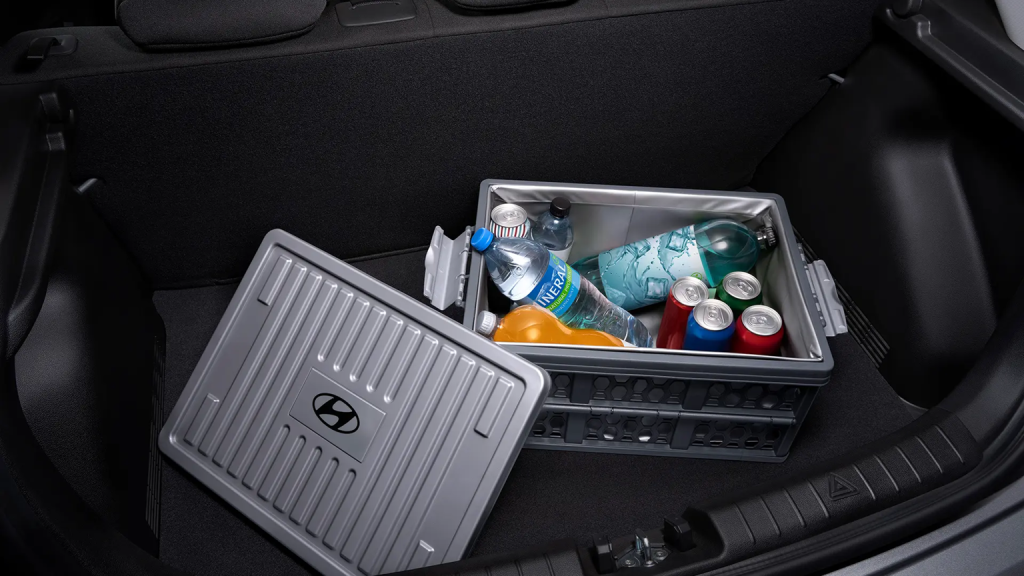 Porta-malas do Hyundai HB20S aberto, com garrafas e sacolas de bebidas acomodadas, destacando a capacidade de 475 litros do compartimento.