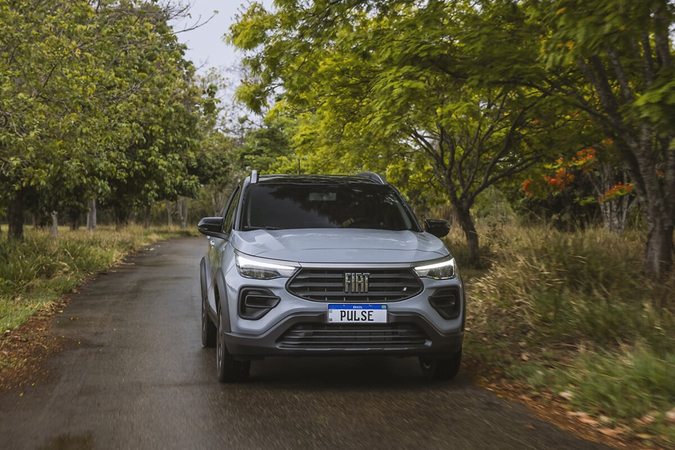 Fiat Pulse visto de frente em ambiente arborizado, com destaque para o design robusto do SUV compacto