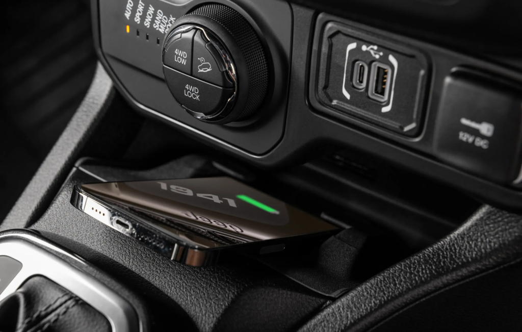 Detalhe do carregador no console central do Jeep Renegade, com porta-objetos e entradas visíveis.