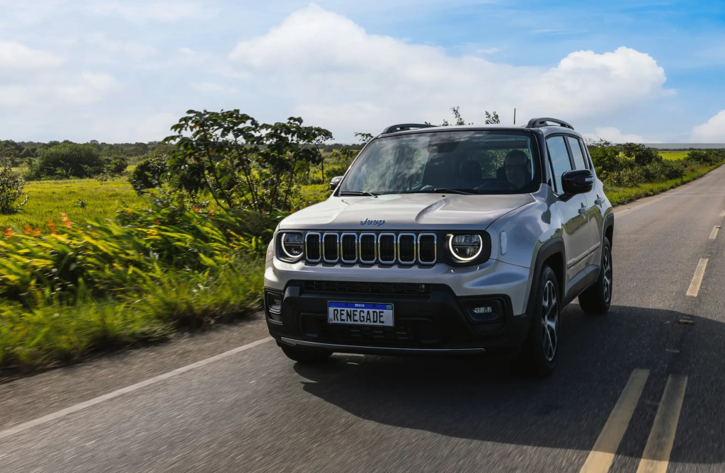 Jeep Renegade cinza em movimento na estrada, destacando design robusto e perfil urbano do SUV.