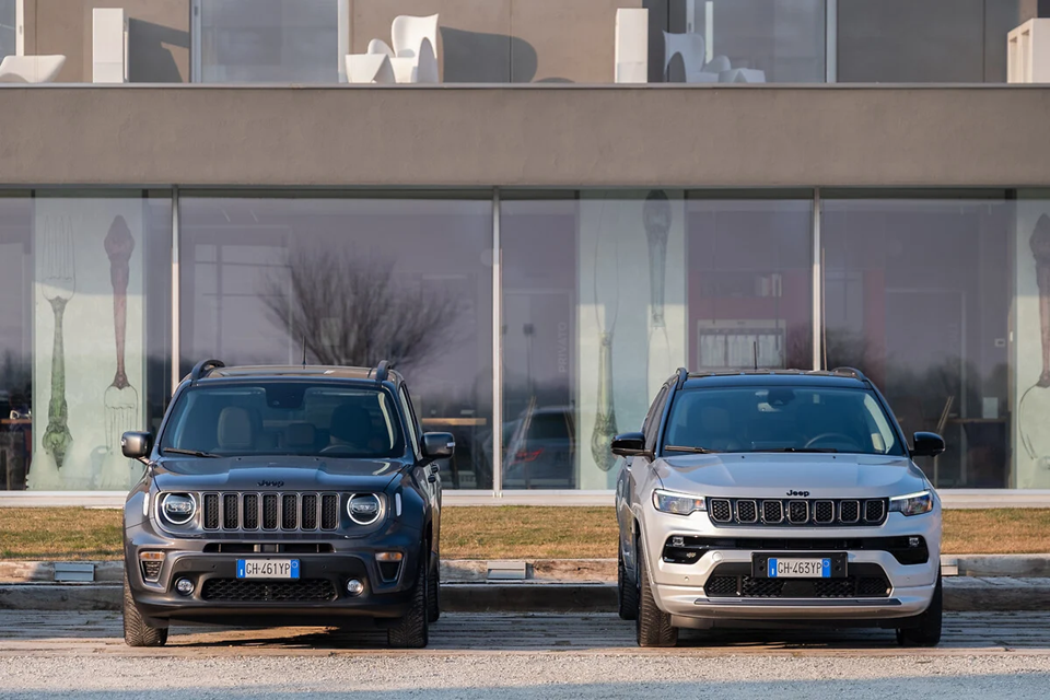 Jeep Renegade e Jeep Compass estacionados lado a lado, destacando diferenças de tamanho, design frontal e estilo de cada SUV.