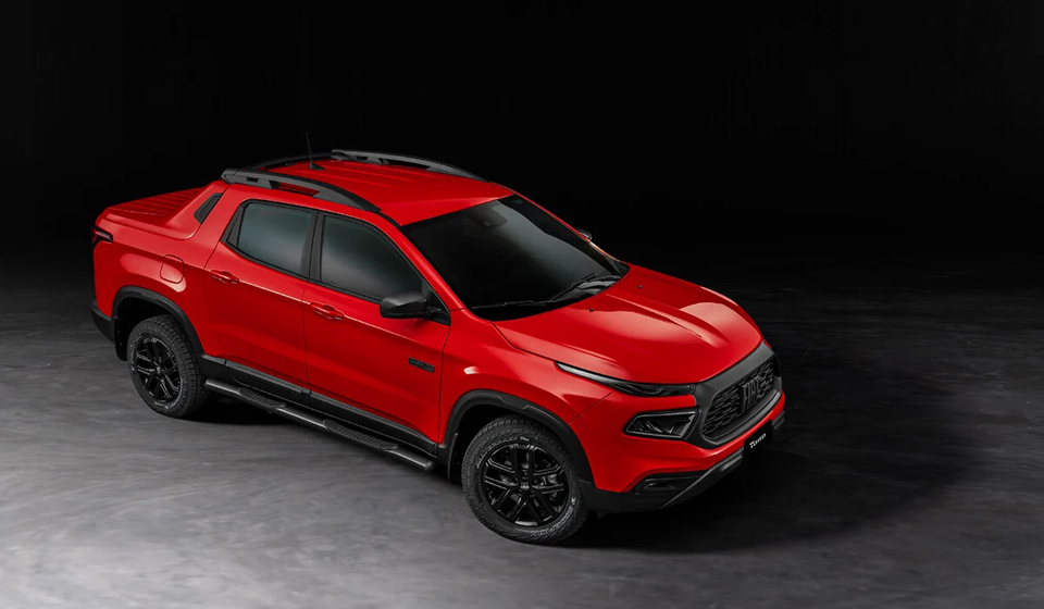 Fiat Toro vermelha em estúdio, vista de cima, destacando o design robusto e as linhas marcantes da carroceria.