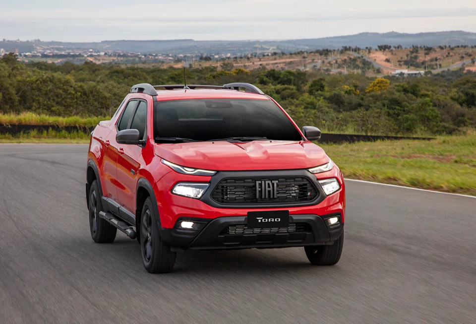 Fiat Toro Ultra vermelha vista de frente, com grade escurecida, faróis full LED e visual imponente.

