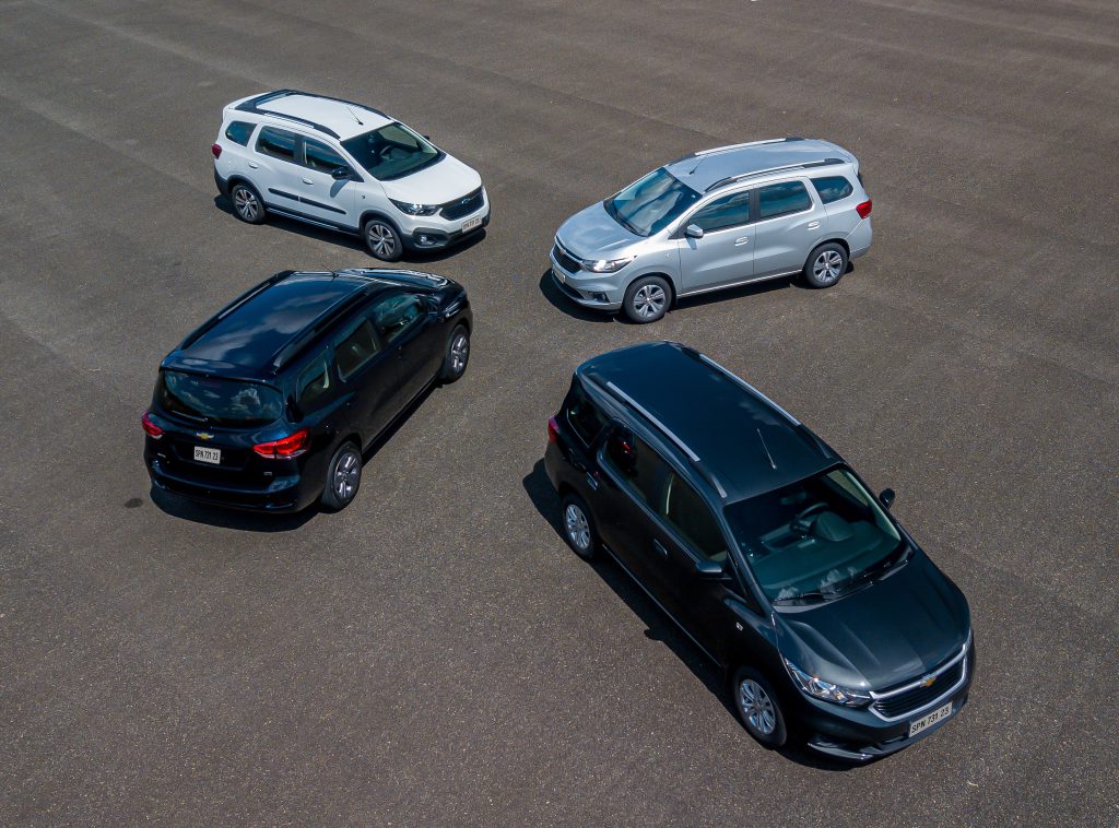Várias Chevrolet Spin de cores diferentes estacionadas frente a frente, destacando variedade de modelos