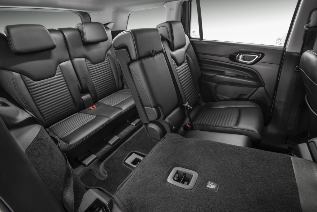 Interior do Jeep Commander branco, bancos traseiros com um assento rebatido para ampliar o espaço de carga.