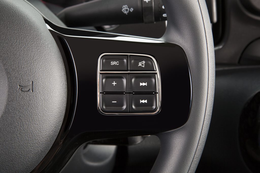 Detalhe do volante do Fiat Mobi, com foco nos botões multifuncionais de controle de áudio e chamadas.