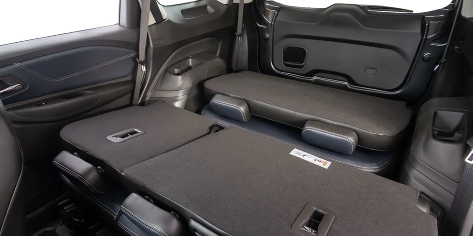 Bancos traseiros da Chevrolet Spin rebatidos, destacando o amplo espaço interno para bagagens.