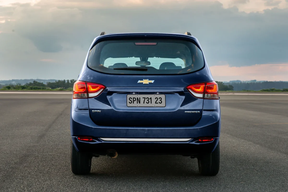 Chevrolet Spin azul estacionada com foco na traseira, evidenciando lanternas e porta-malas amplo.